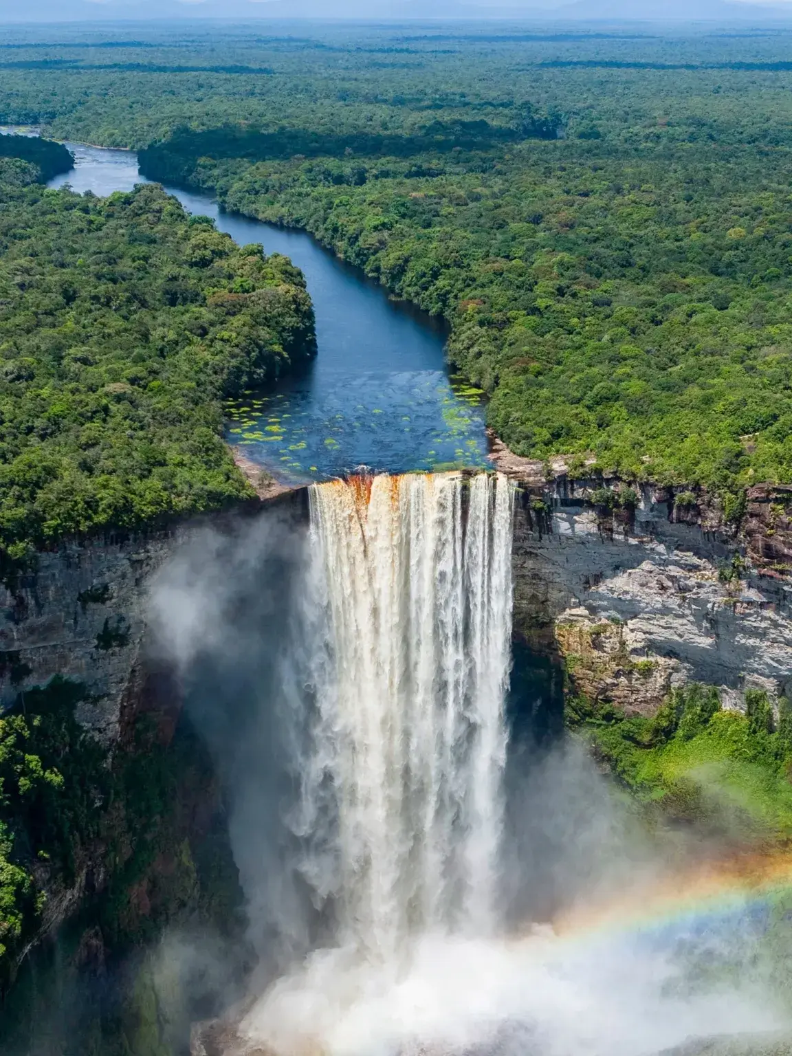 A waterfall with a rainbow in the background.